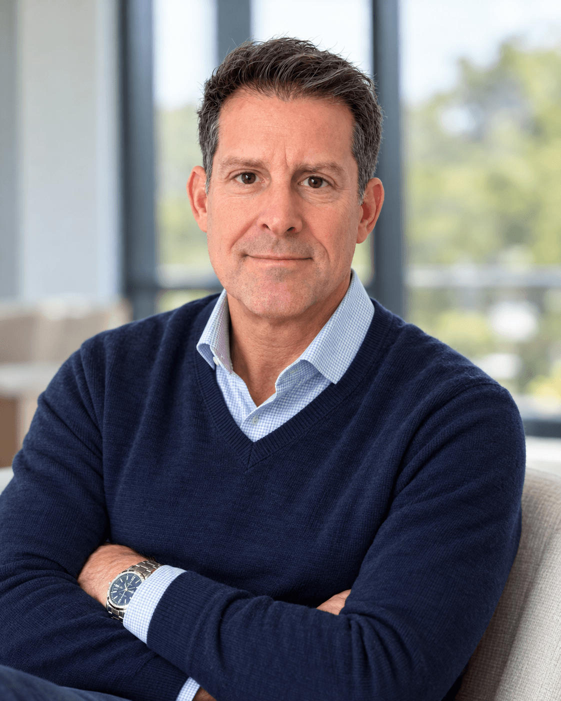 Michael O’Nan in a navy sweater, seated in a bright window-side setting